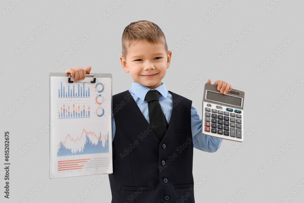 Cute little businessman with calculator and diagrams on grey background