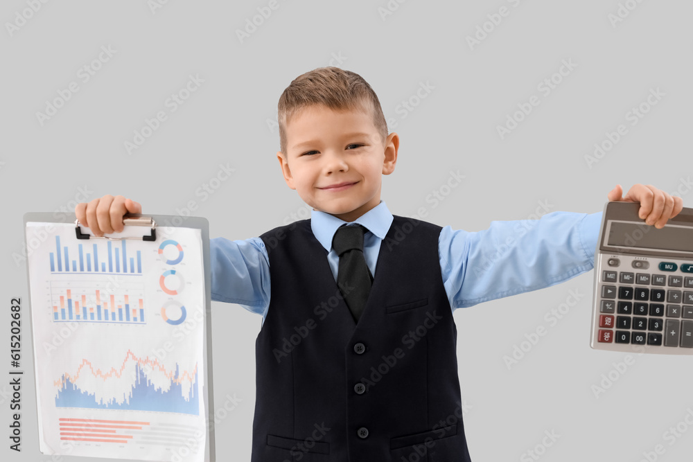 Cute little businessman with calculator and diagrams on grey background