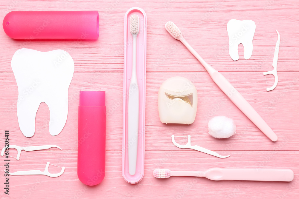 Composition with dental floss, toothpicks and brushes on pink wooden background