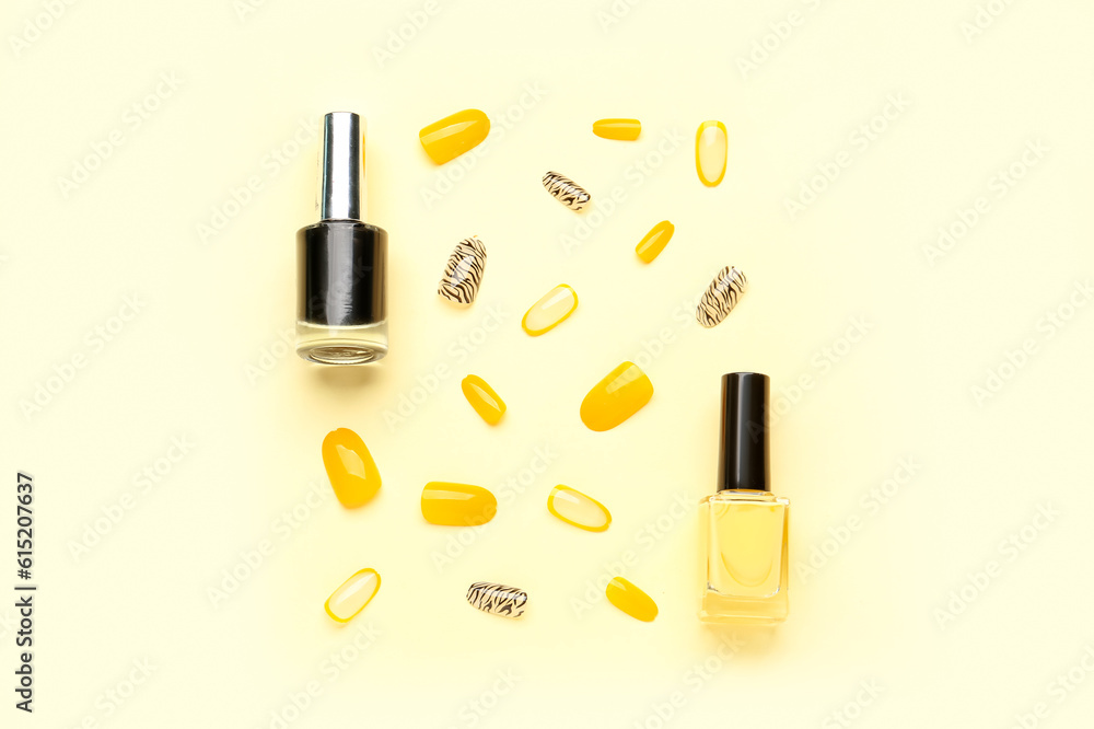 Press-on nails with polishes on yellow background