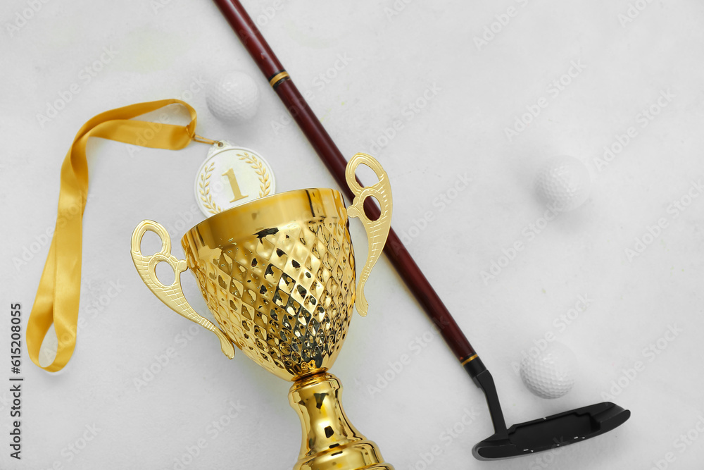 Gold cup with golf club and balls on white background