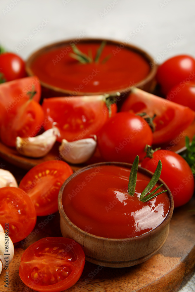 Bowl with tasty ketchup and fresh vegetables on table