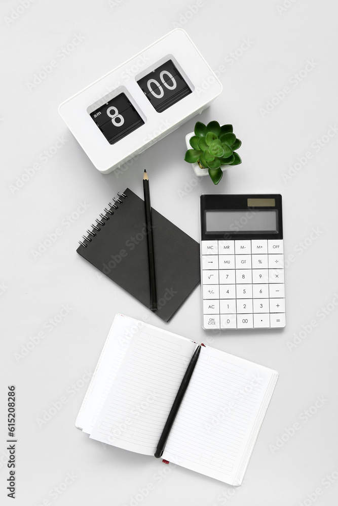 Composition with notepad, calculator, clock and plant on light background