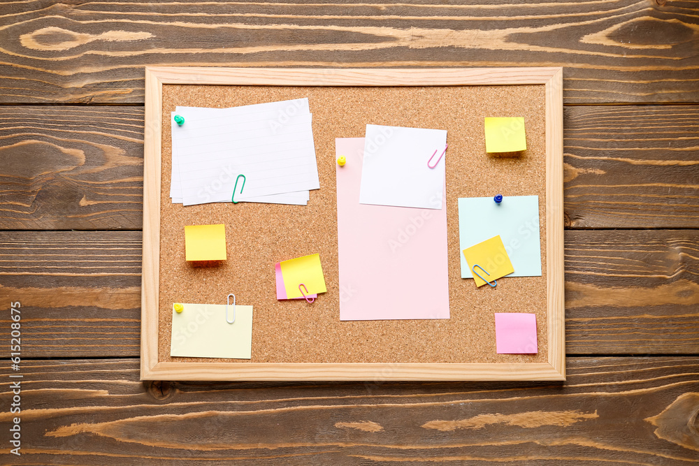 Board with different sticky notes on wooden background