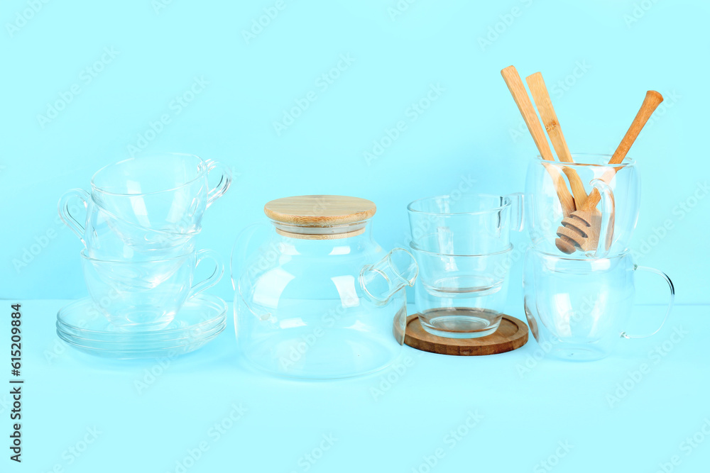 Stylish glass tea set on blue background