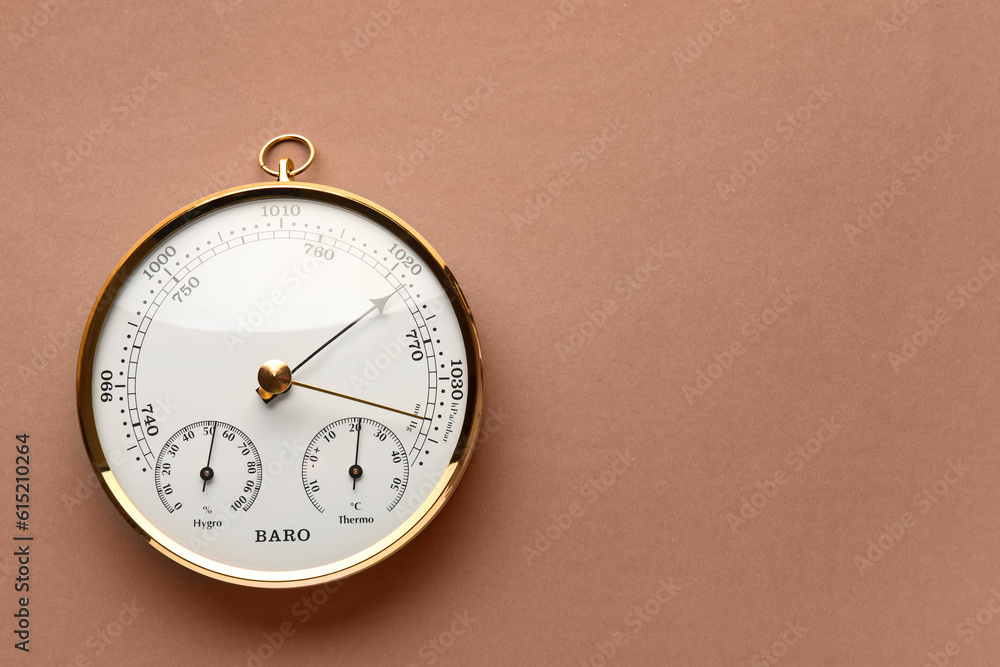 Aneroid barometer on brown background