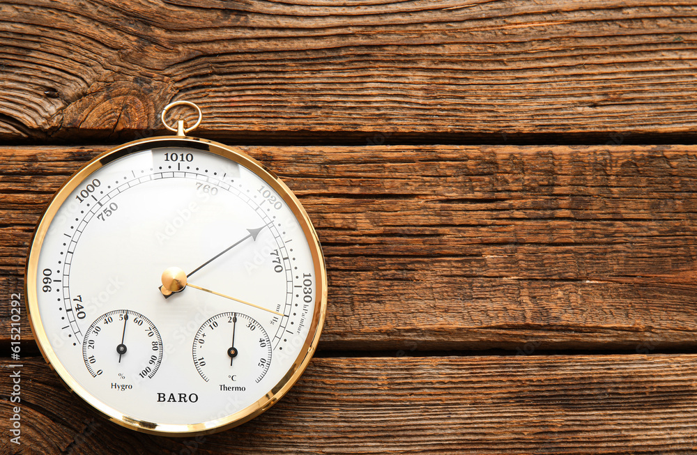 Aneroid barometer on brown wooden background