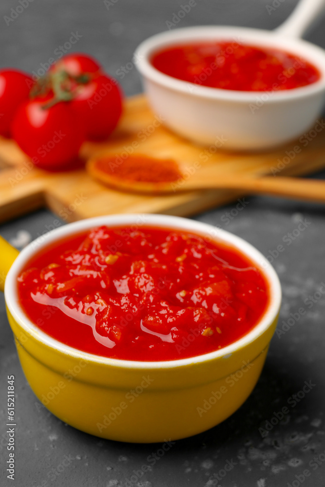 Bowl with tasty tomato sauce on blue background, closeup