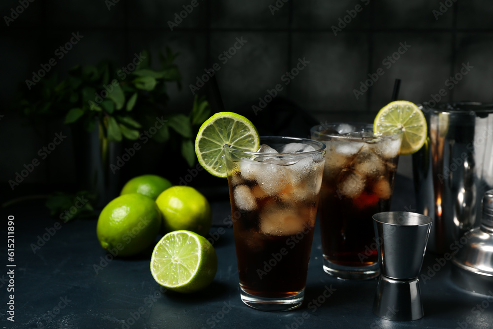 Glasses of cold Cuba Libre cocktail on dark background