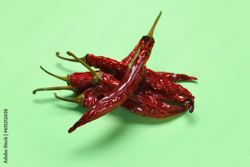 Dry hot chili peppers on pale green background