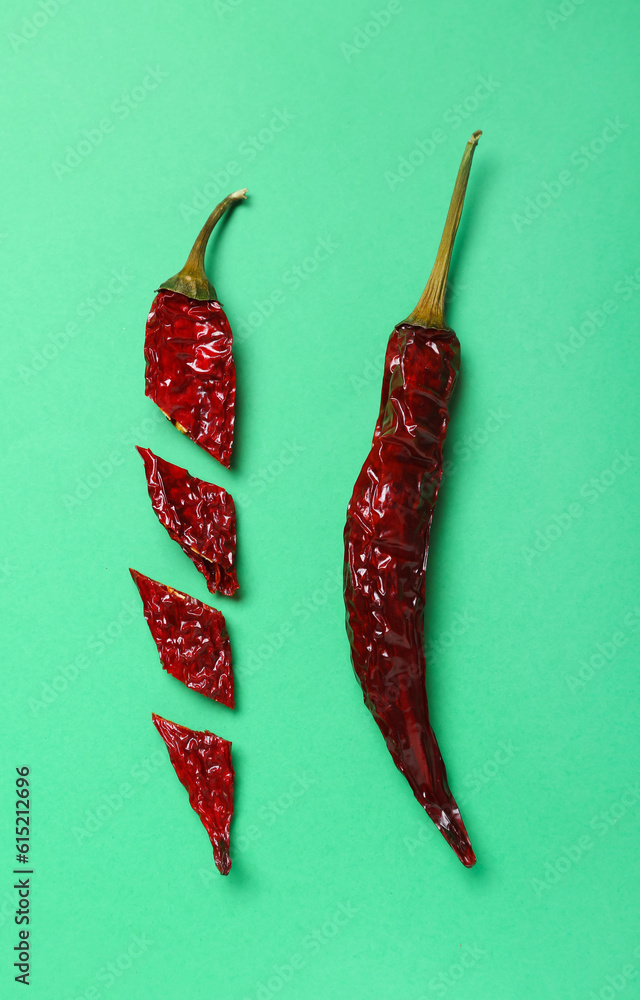 Cut chili peppers on green background