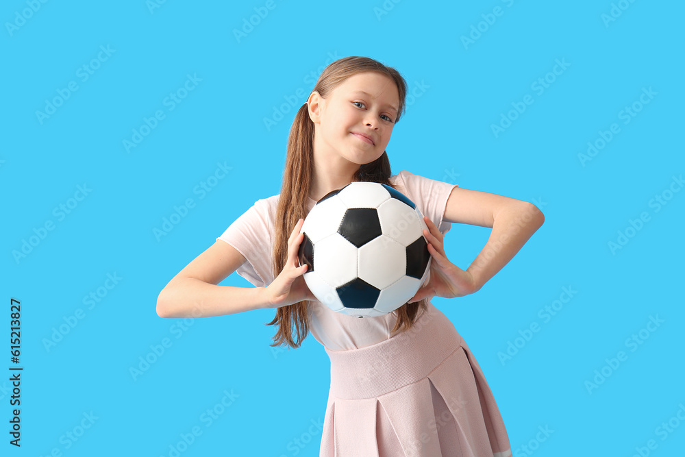 Little girl with soccer ball on blue background