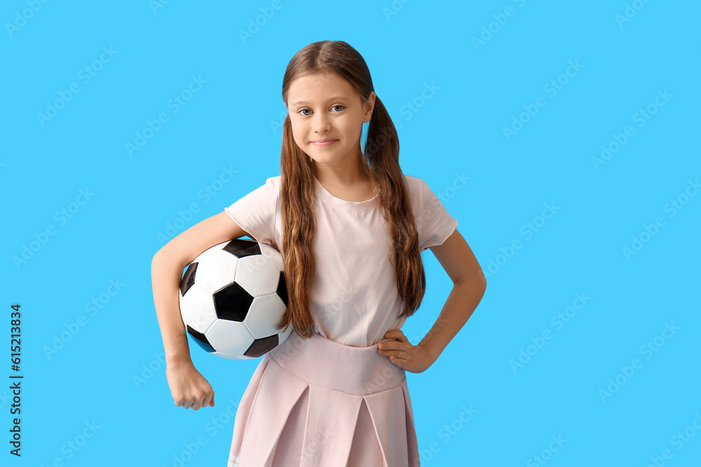 Little girl with soccer ball on blue background