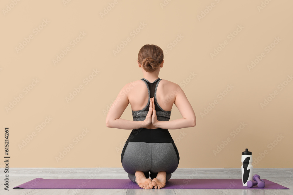 Sporty young woman doing yoga indoors