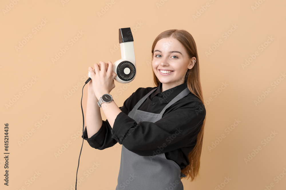 Female hairdresser with dryer on beige background