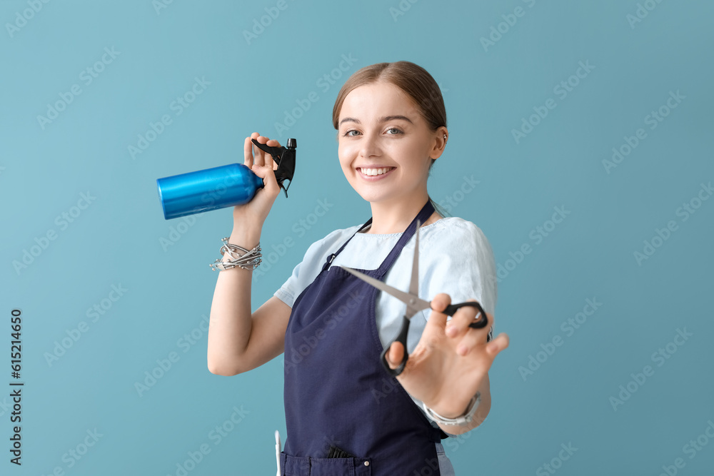 Female hairdresser with scissors and spray on blue background