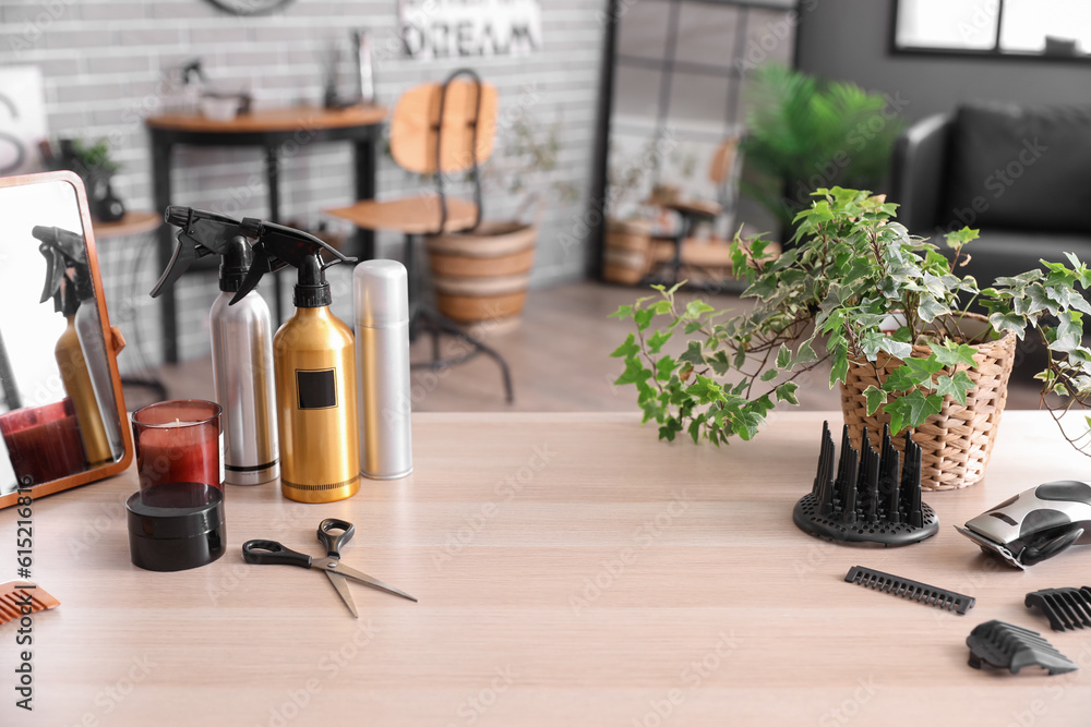 Different hairdressing tools and tea cup on table in beauty salon