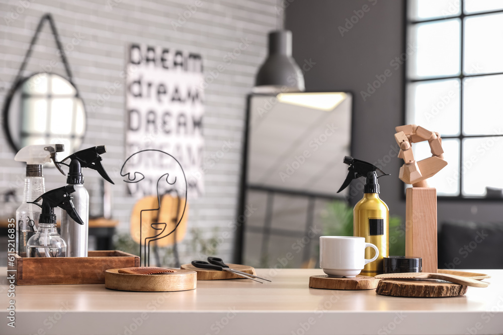 Different hairdressing tools and tea cup on table in beauty salon