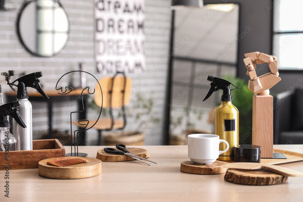 Different hairdressing tools and tea cup on table in beauty salon