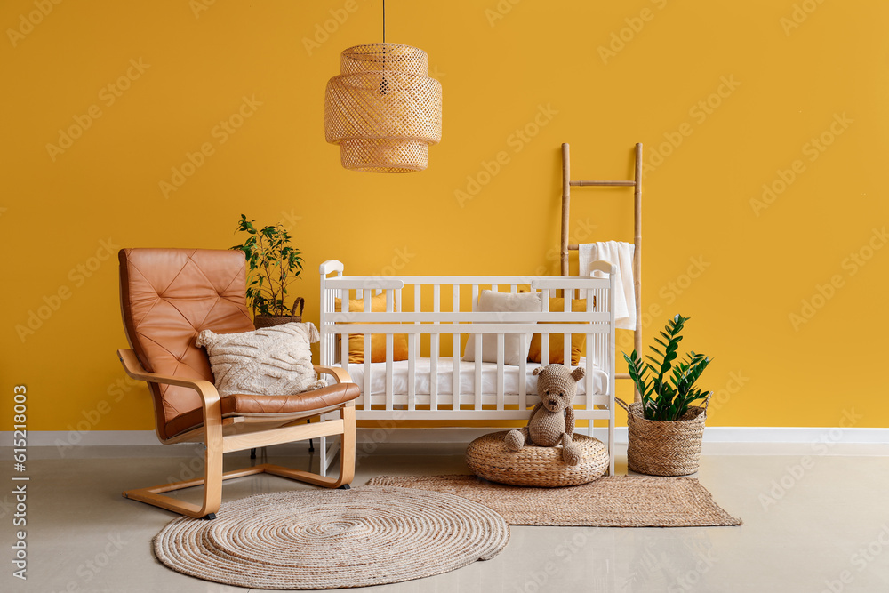 Interior of stylish bedroom with baby crib, armchair and ladder