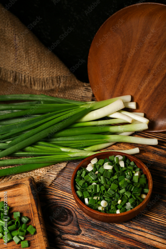 Bowl with fresh cut green onion on table