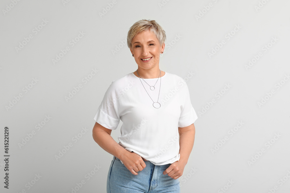 Mature blonde woman on light background