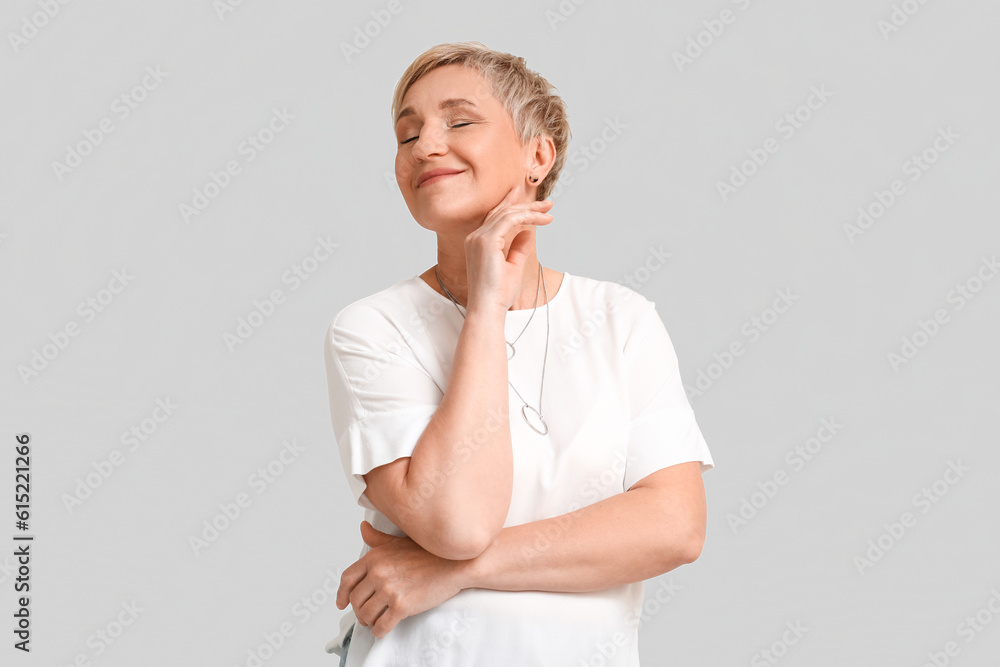 Mature blonde woman on light background