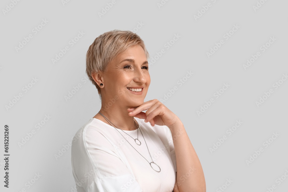 Mature blonde woman on light background