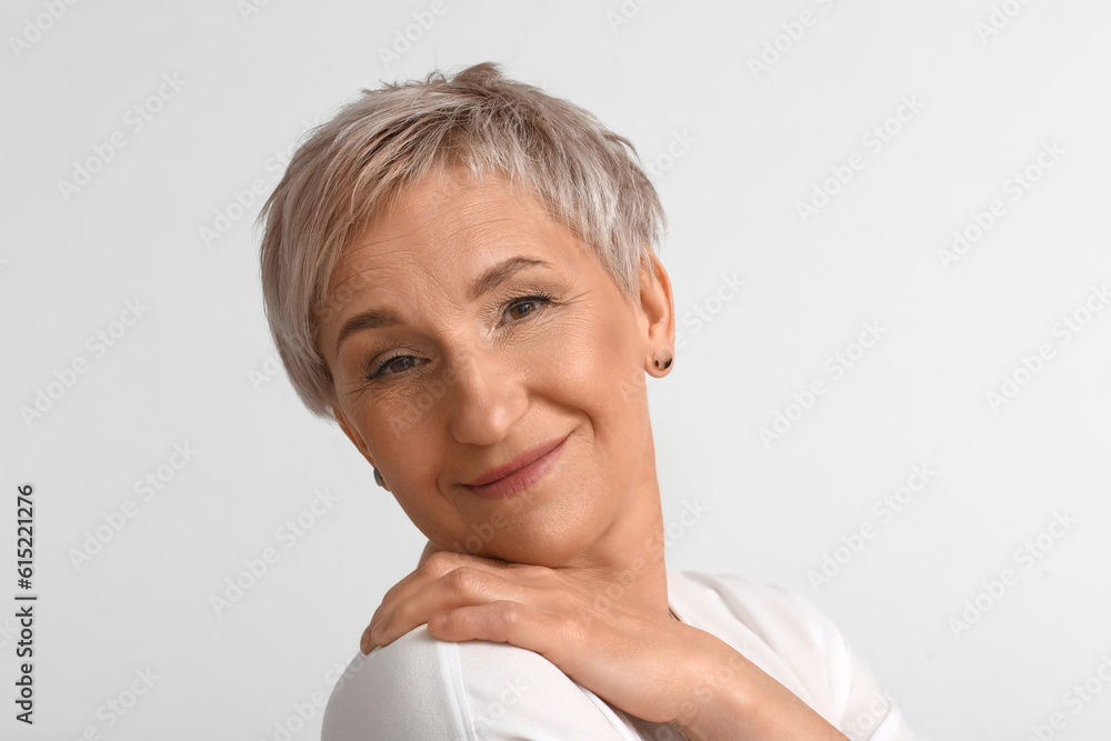 Mature blonde woman on light background, closeup