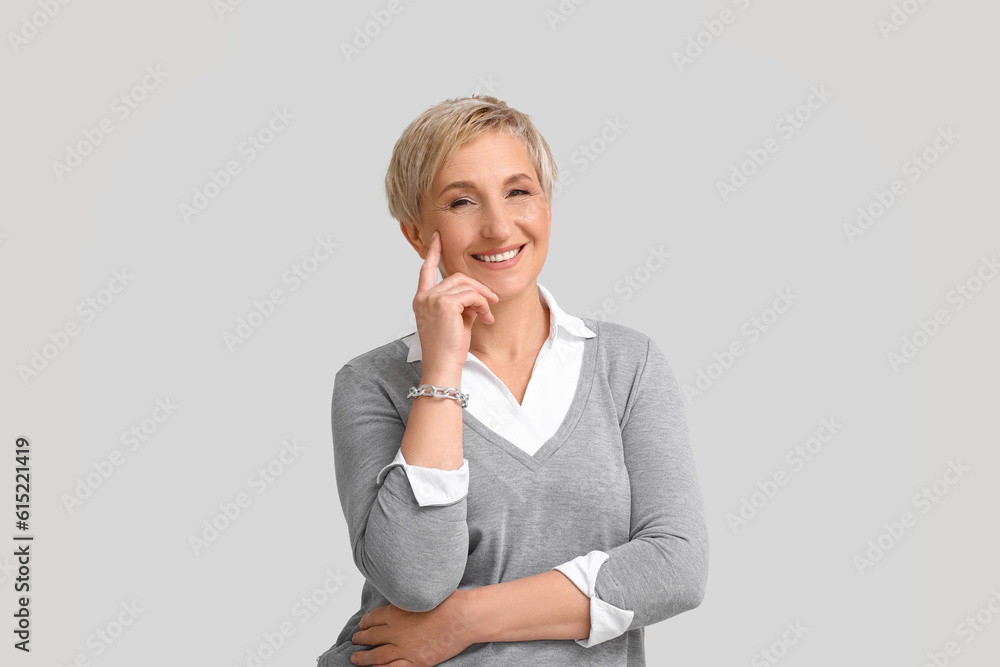 Mature blonde woman on light background