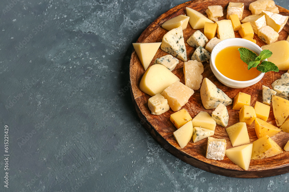 Plate with pieces of tasty cheese and honey on blue background, closeup