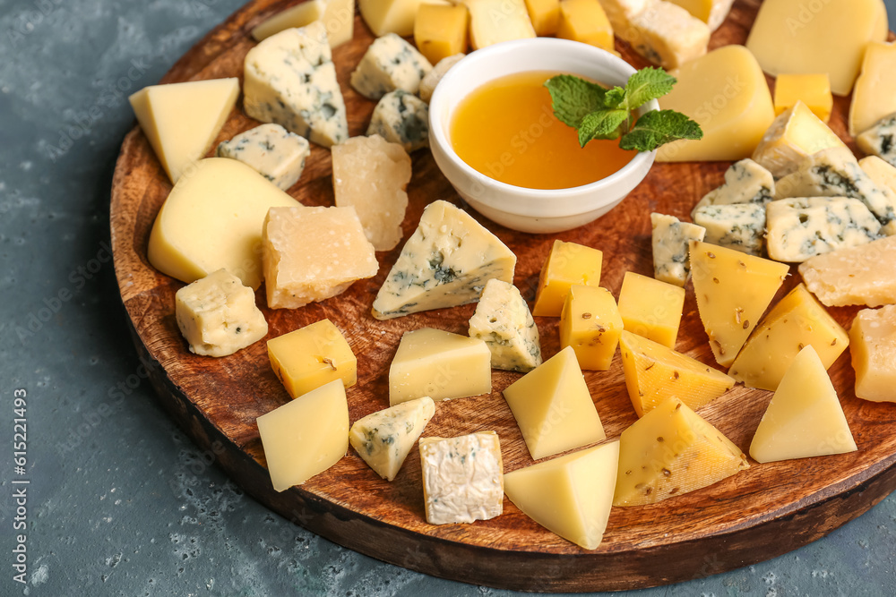 Plate with pieces of tasty cheese and honey on blue background, closeup