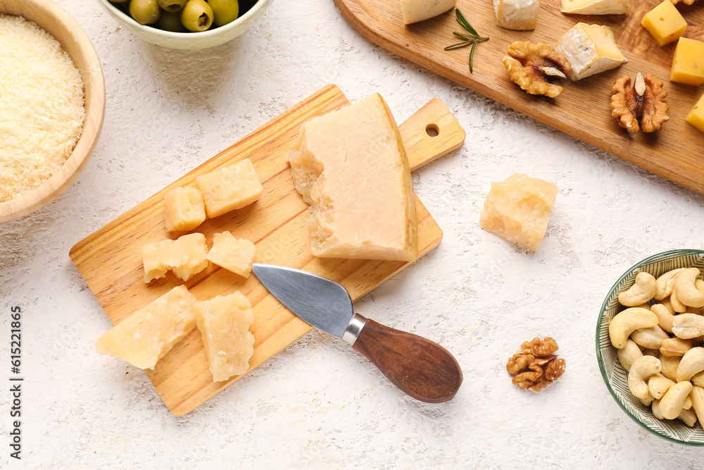 Wooden board with pieces of tasty cheese on light background