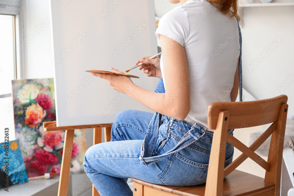 Female artist painting picture in  workshop