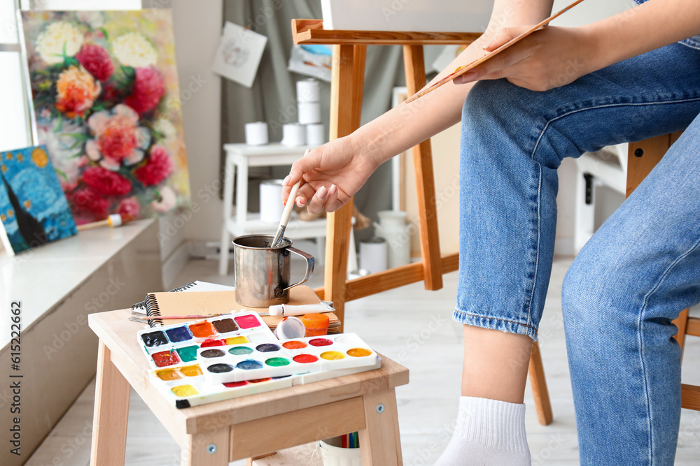 Female artist painting picture in  workshop