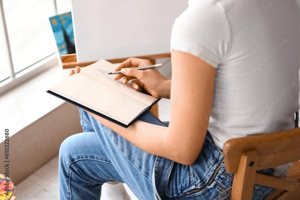 Young female artist drawing sketch in workshop