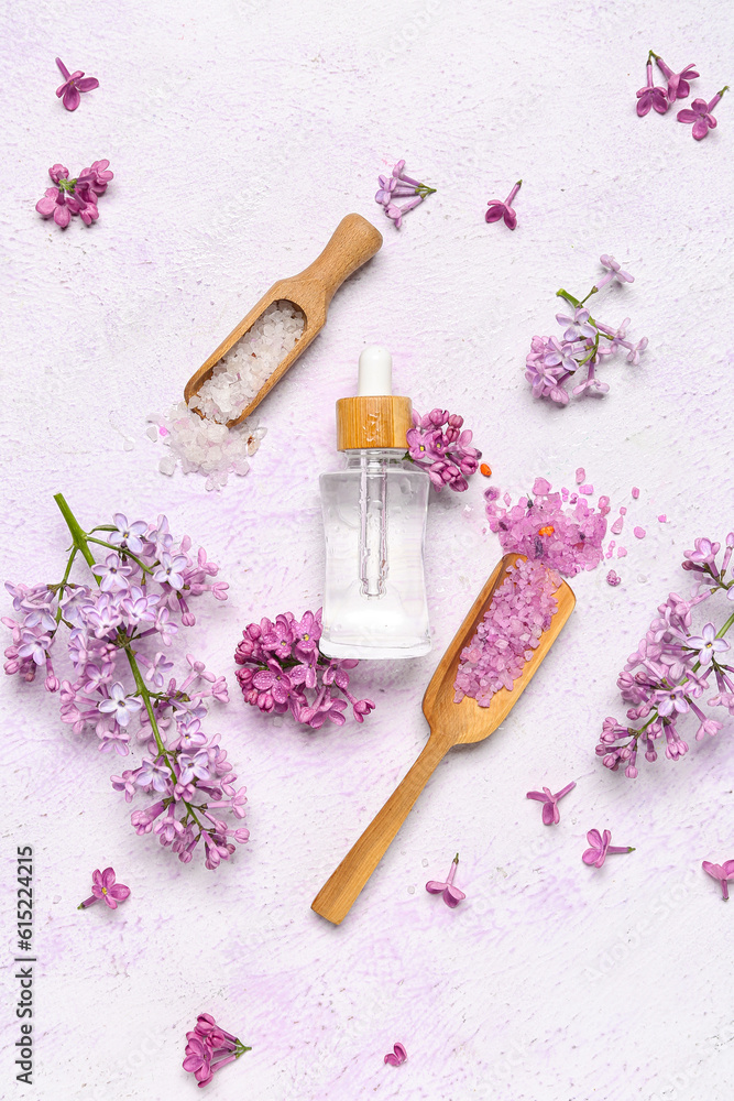 Composition with bottle of lilac essential oil, spoons with sea salt and flowers on light background