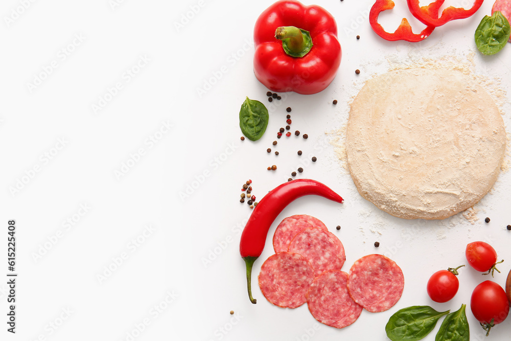 Raw dough and ingredients for preparing pizza on white background