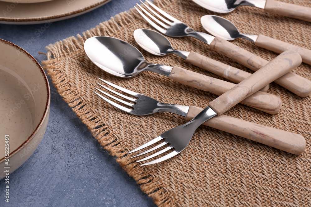 Stainless steel cutlery with plastic handles on blue background