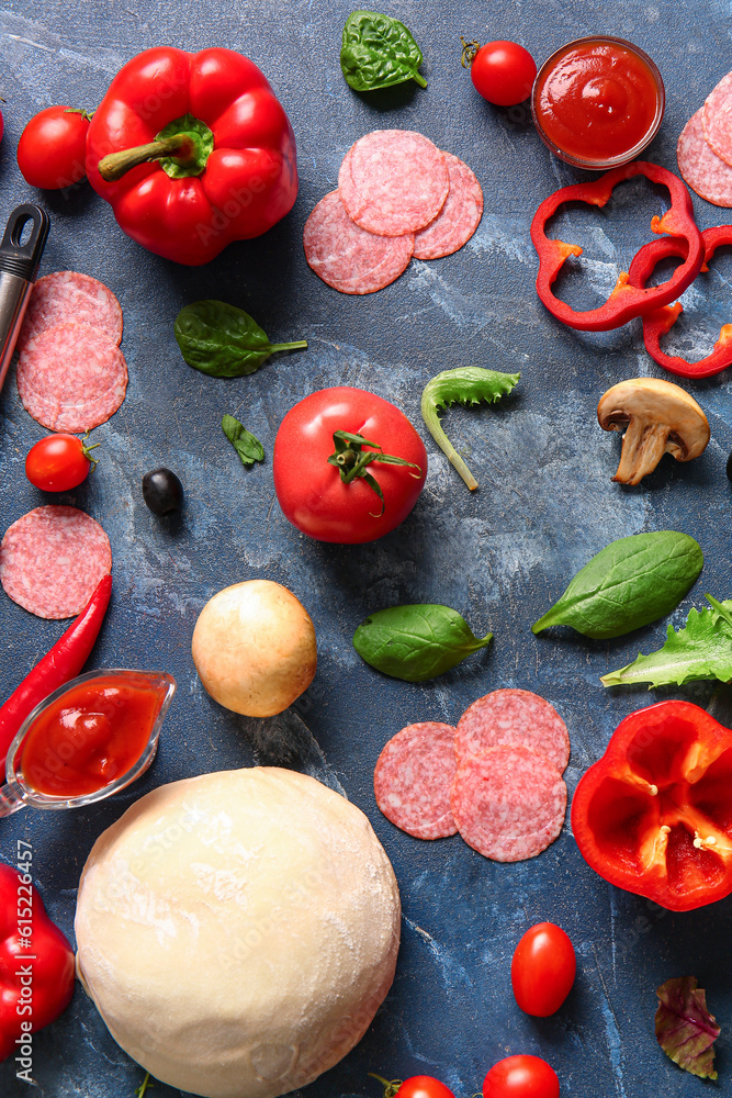 Different ingredients for preparing pizza on blue background