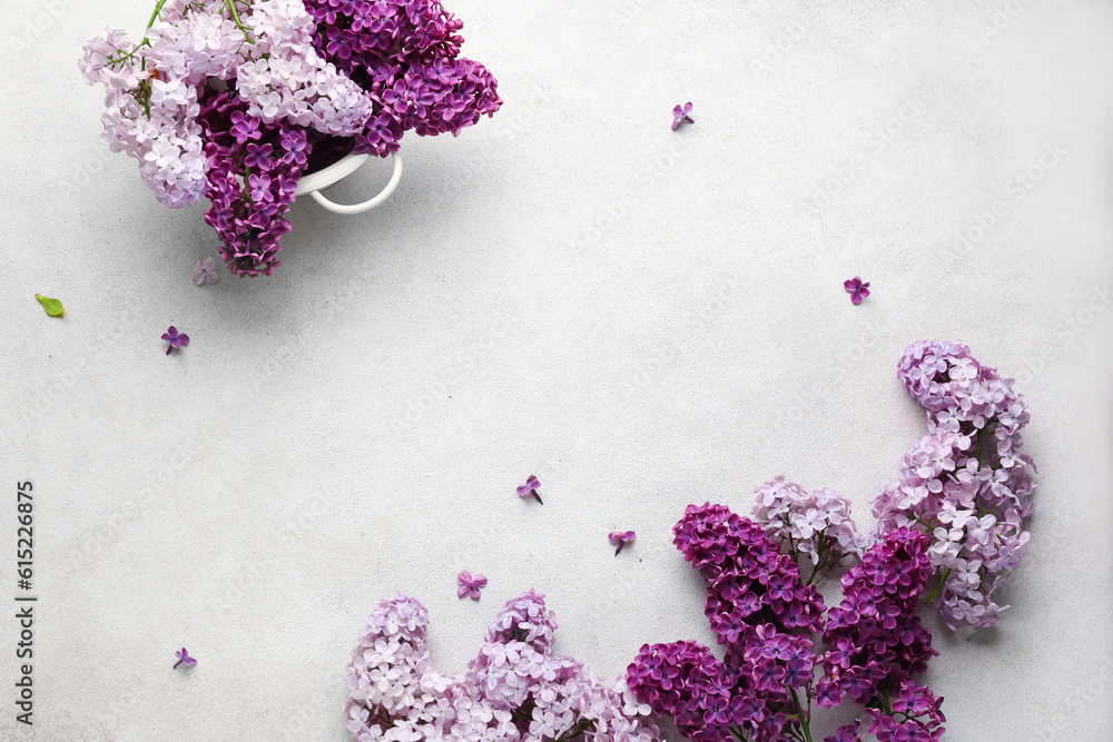 Colander with beautiful fragrant lilac flowers on white textured background