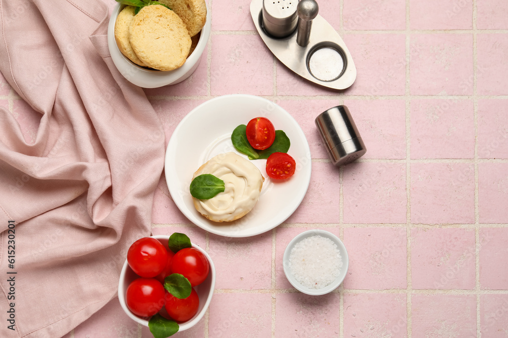 Plate of tasty crouton with cream cheese and fresh tomatoes on pink tile background