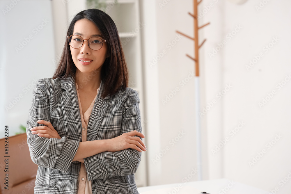 Beautiful Asian businesswoman in stylish eyeglasses in office