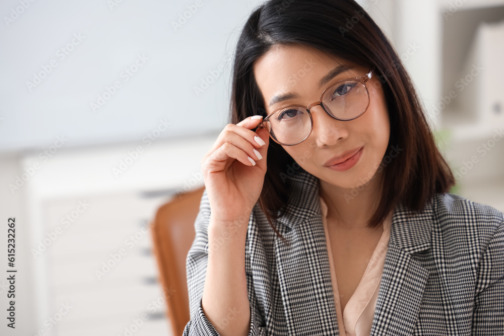 Beautiful Asian businesswoman in stylish eyeglasses in office, closeup