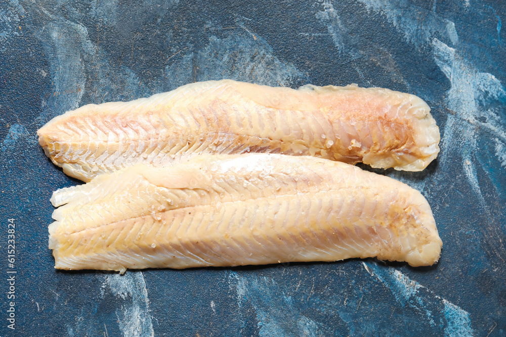 Raw codfish fillet on blue background