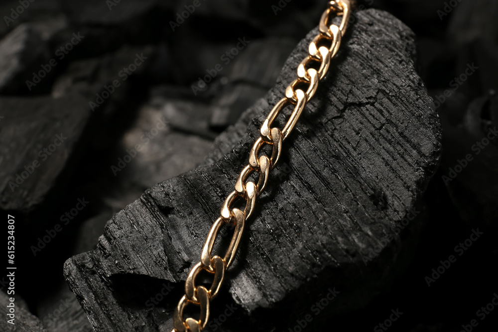 Beautiful chain bracelet on black charcoal, closeup