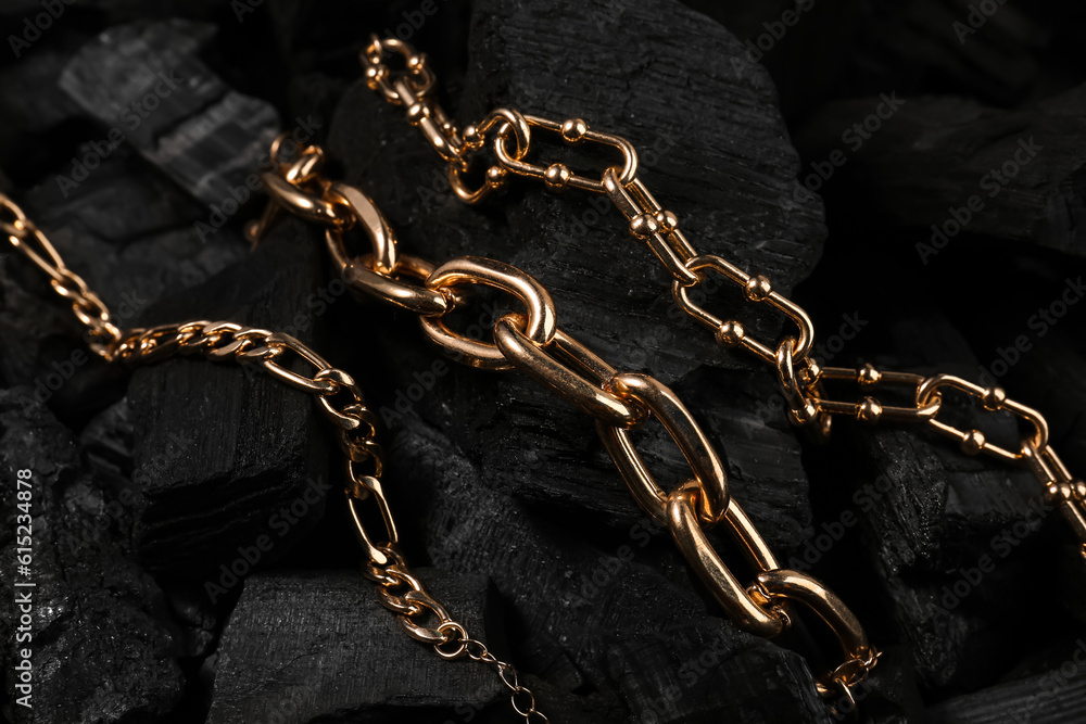 Beautiful chain bracelets on black charcoal, closeup