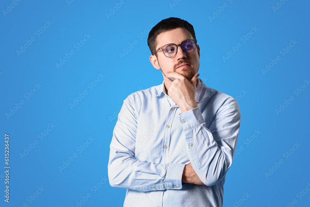 Handsome man in stylish eyeglasses on blue background