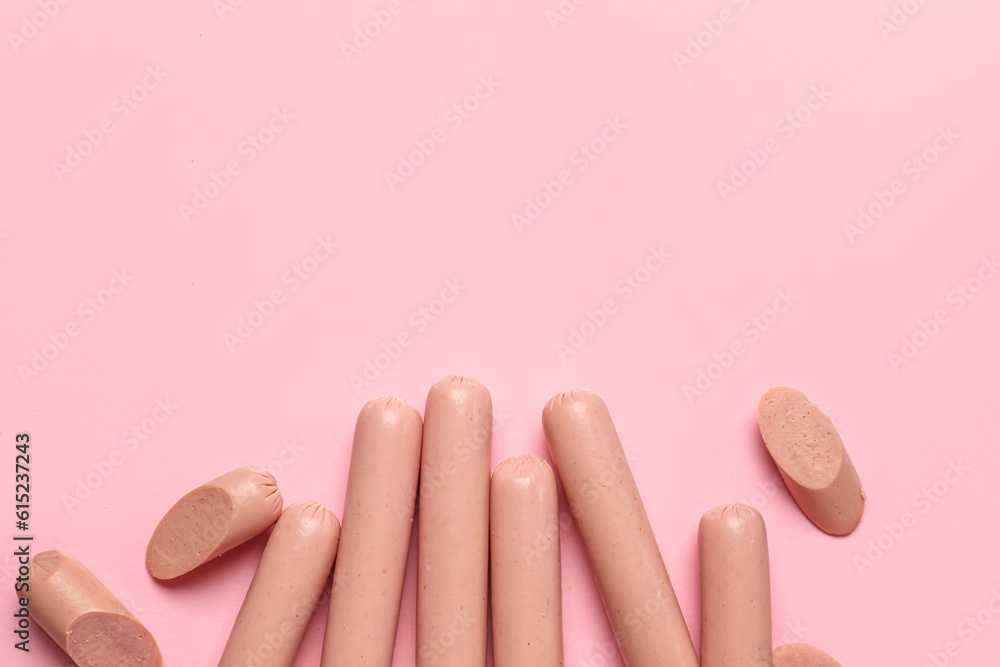 Tasty thin sausages on pink background