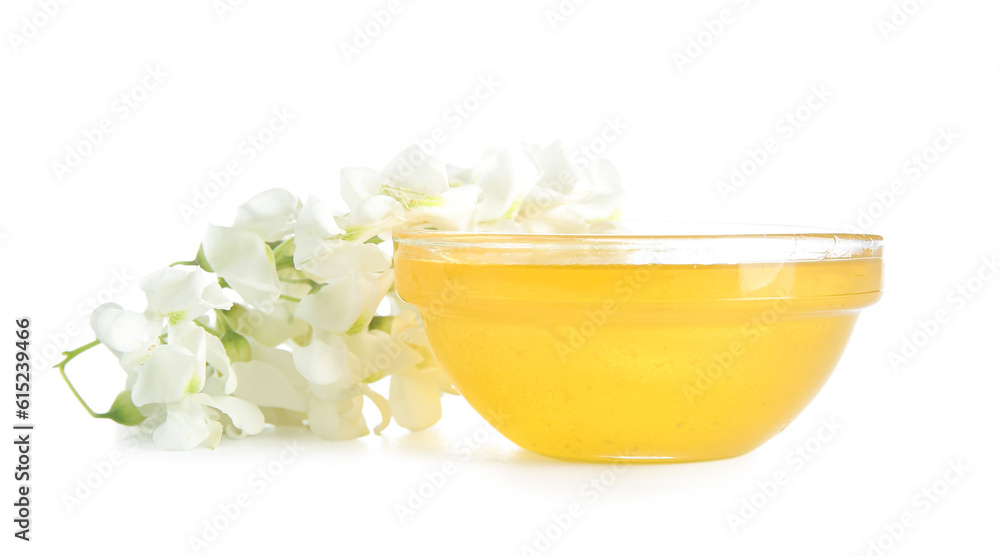 Bowl of honey with flowers of acacia on white background